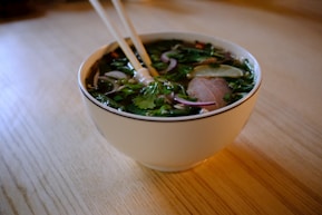 A bowl of soup with chopsticks in it