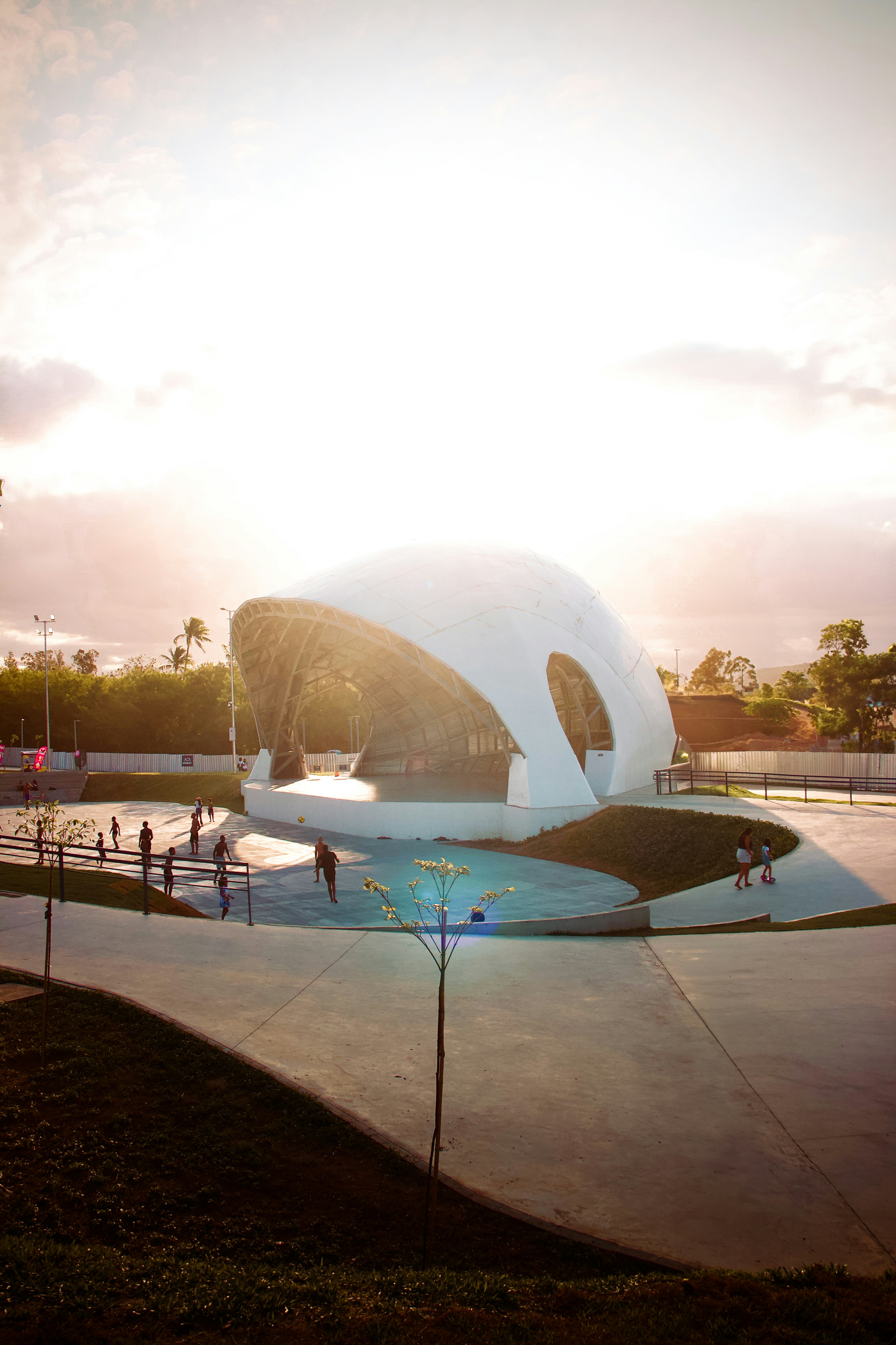 A large white building sitting on top of a lush green field