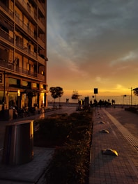 A city street at sunset with people walking on the sidewalk