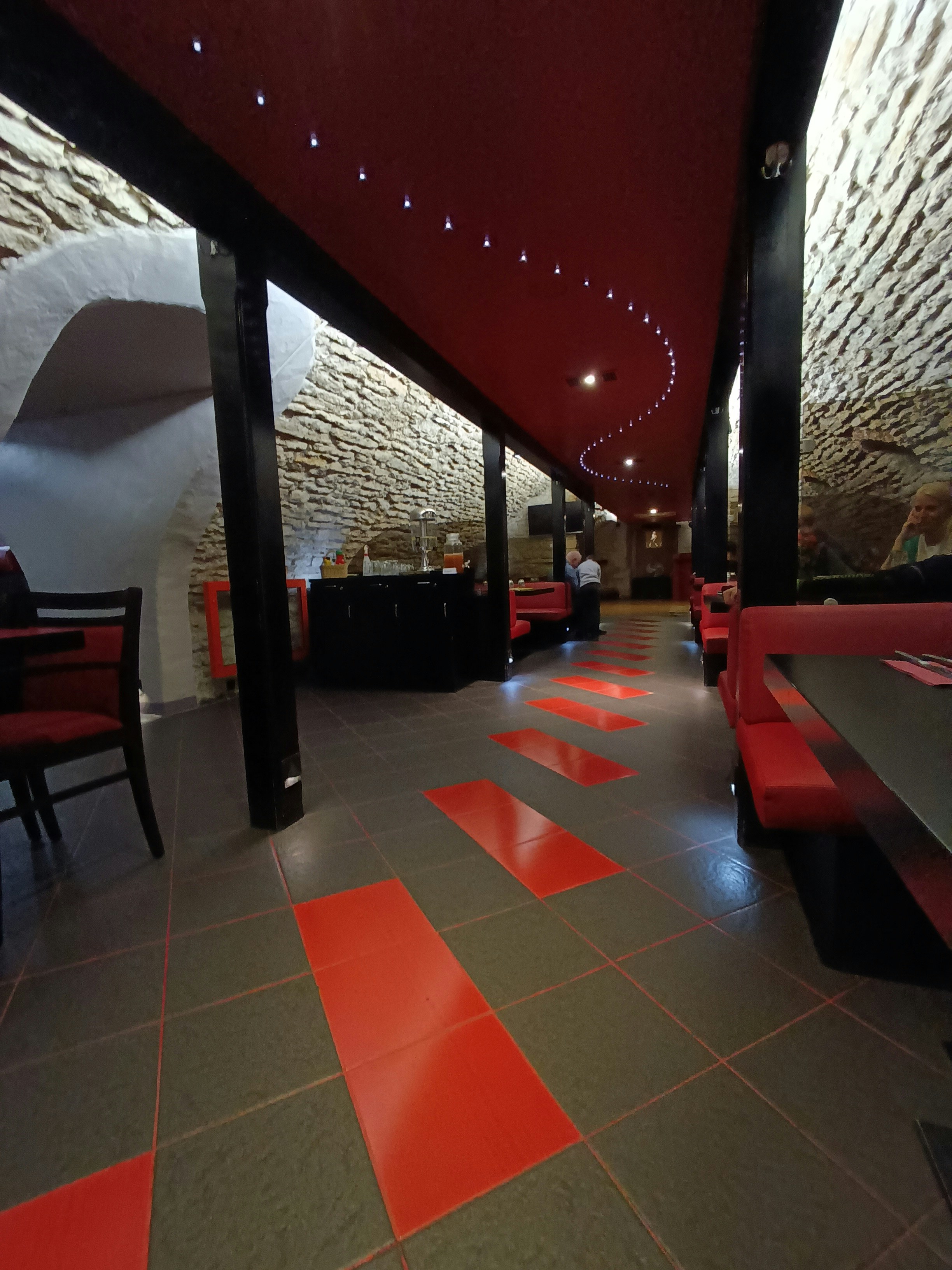 Un ristorante con tavoli e sedie rosse e nere