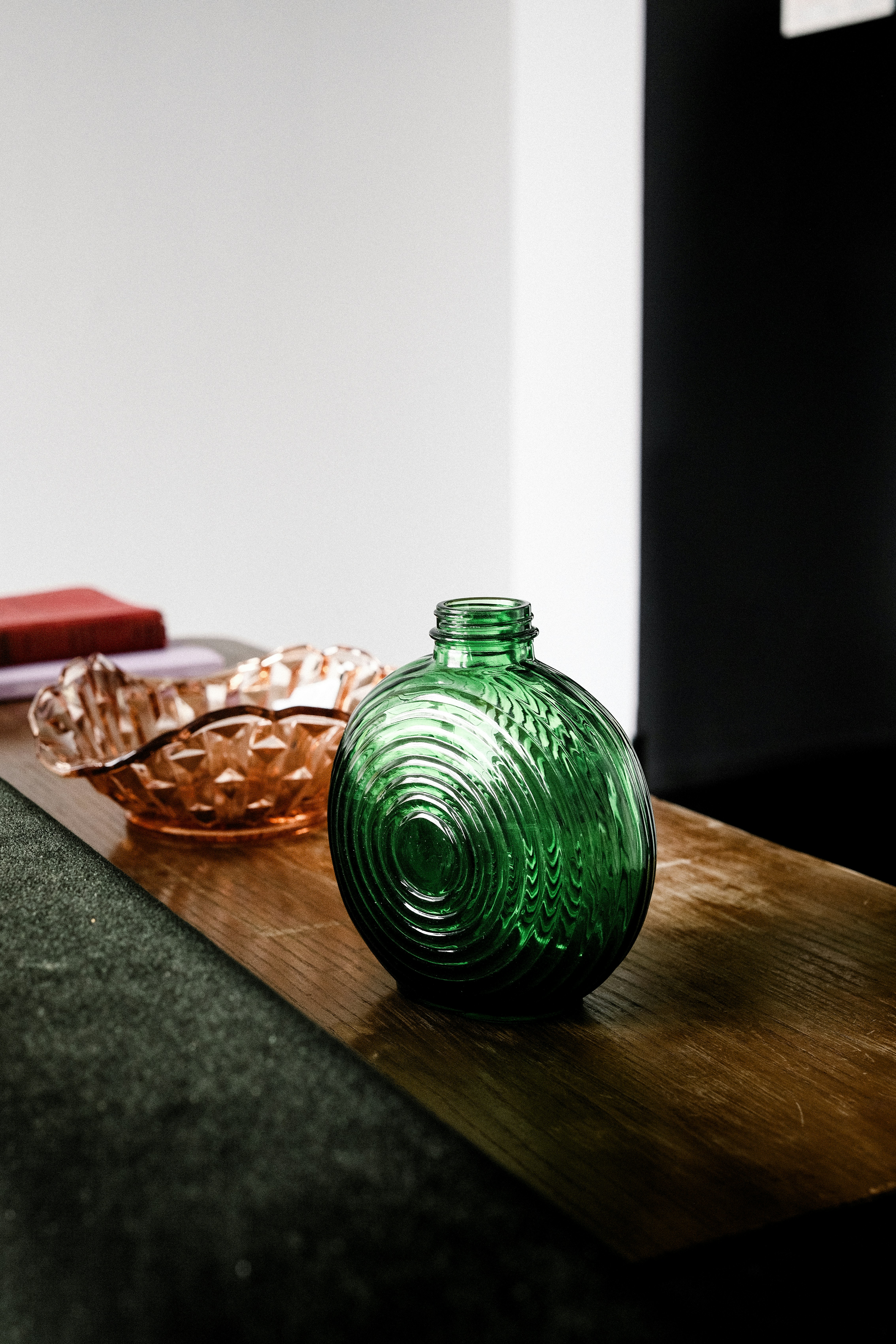 A green vase sitting on top of a wooden table photo – Free Jar Image on ...