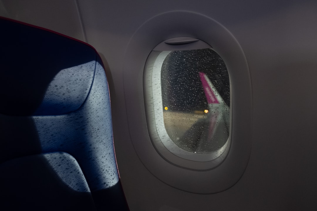 An airplane window with a view of a plane wing,