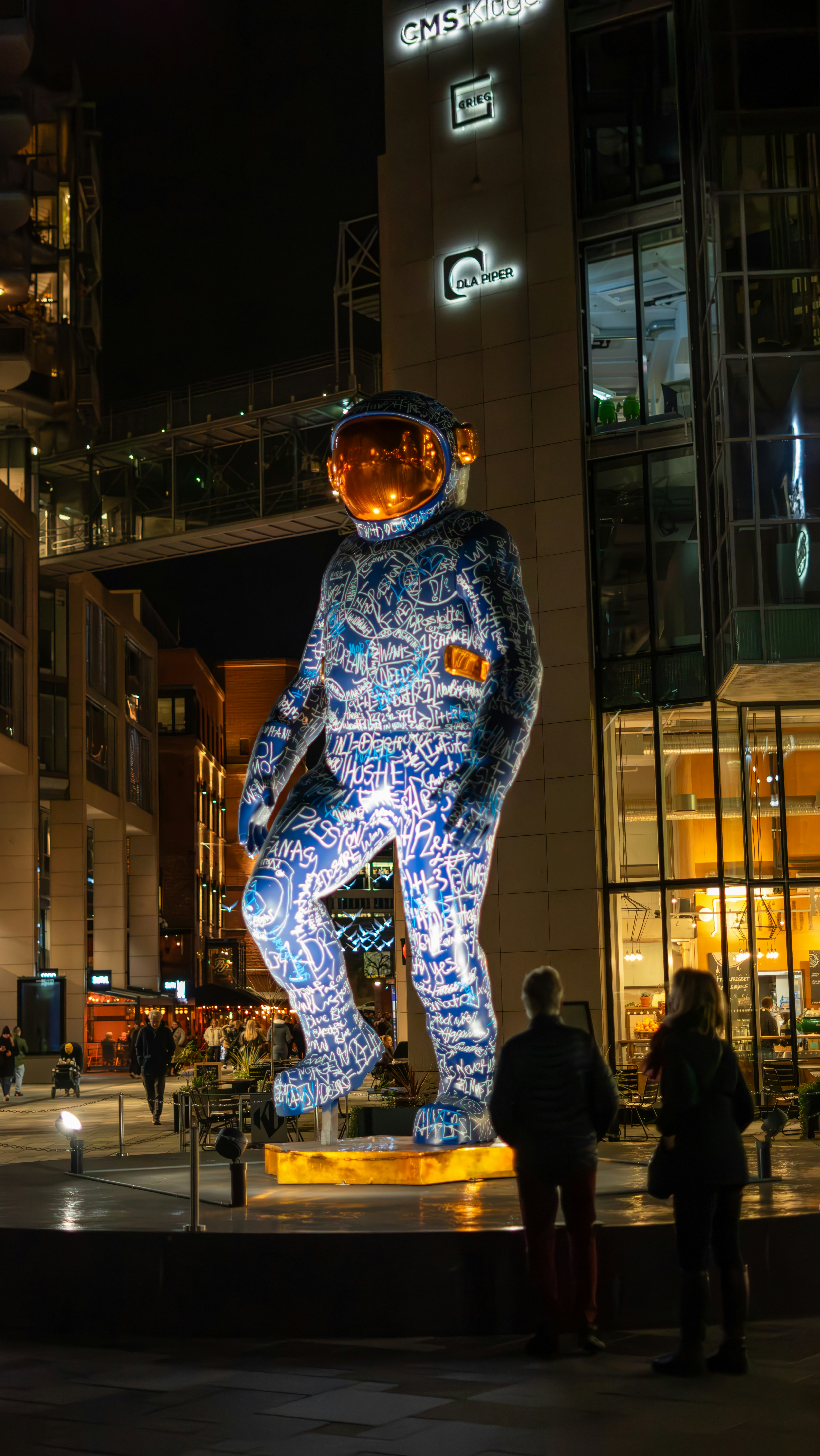 A statue of a man in a blue suit in front of a building