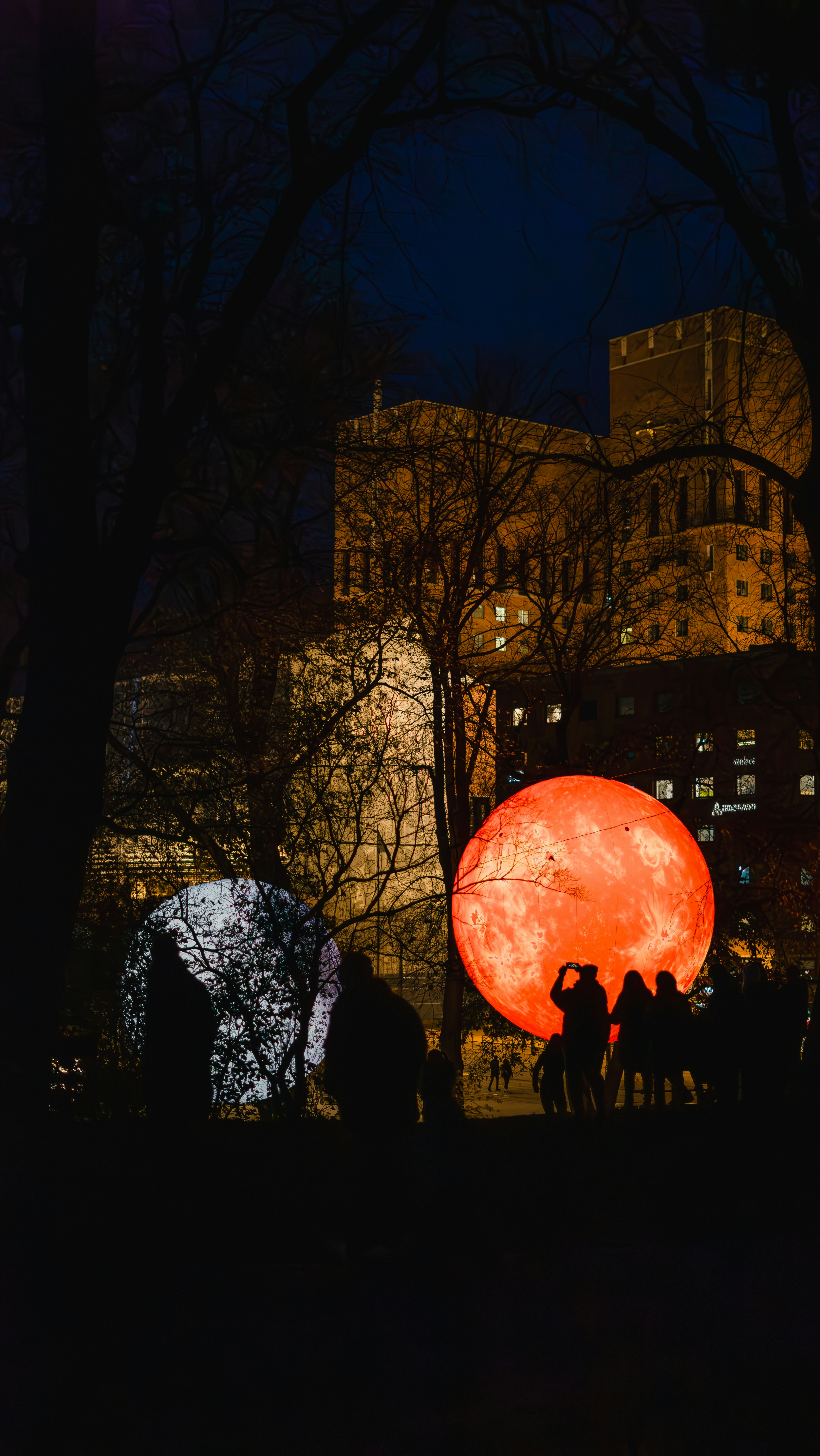 A group of people standing around a giant red ball