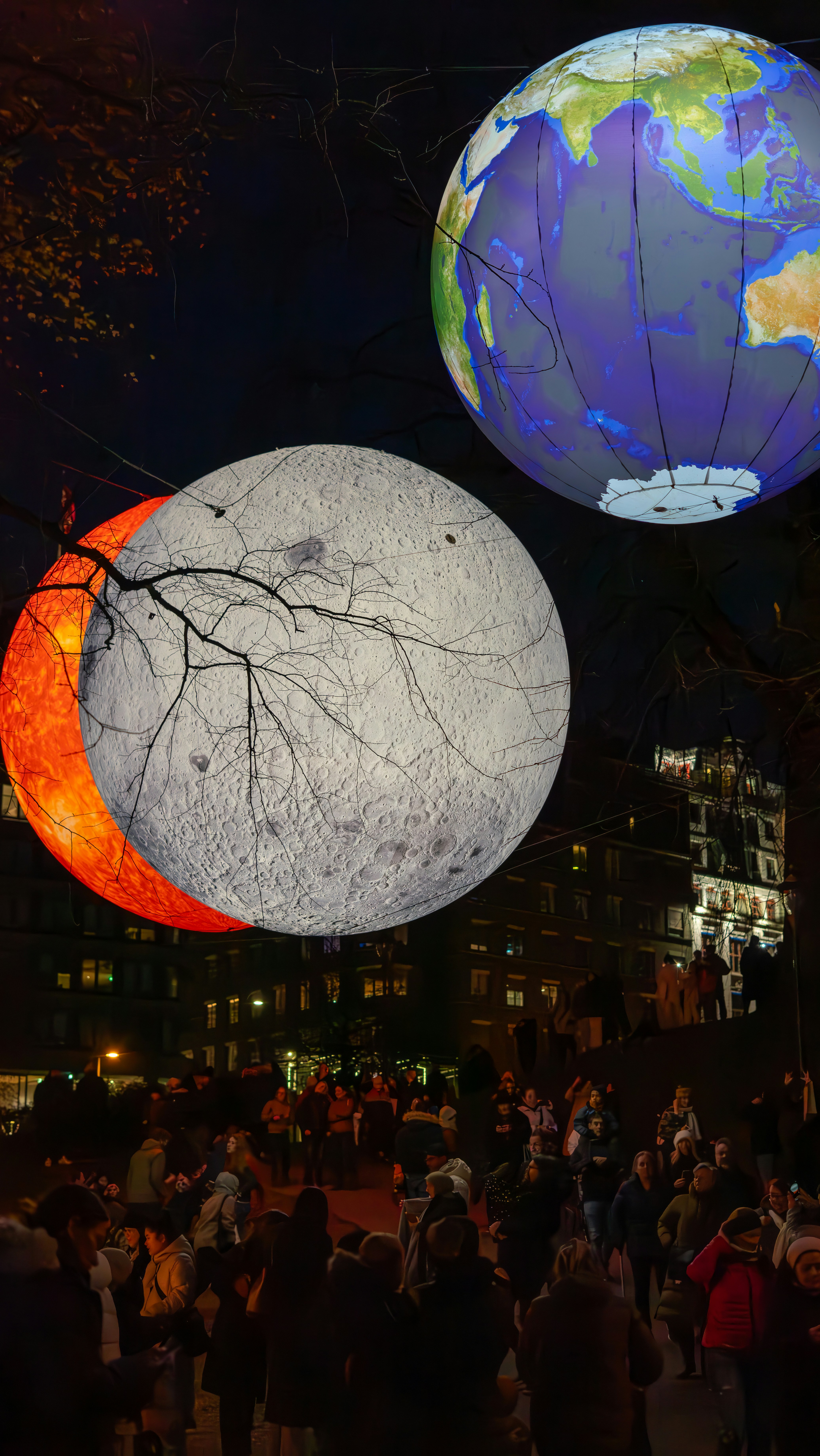 A group of people standing around a large display of planets