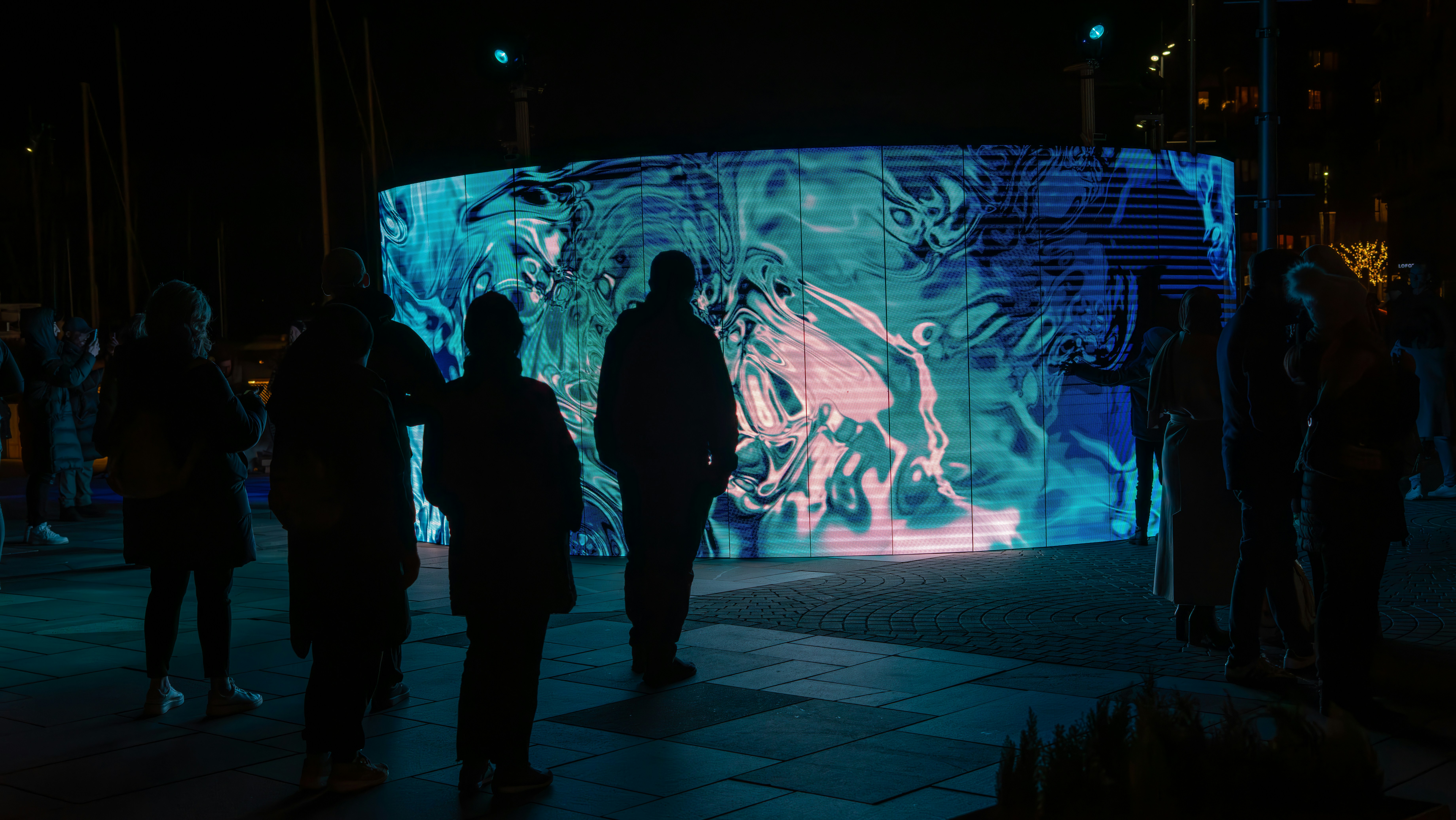 A group of people standing in front of a large screen