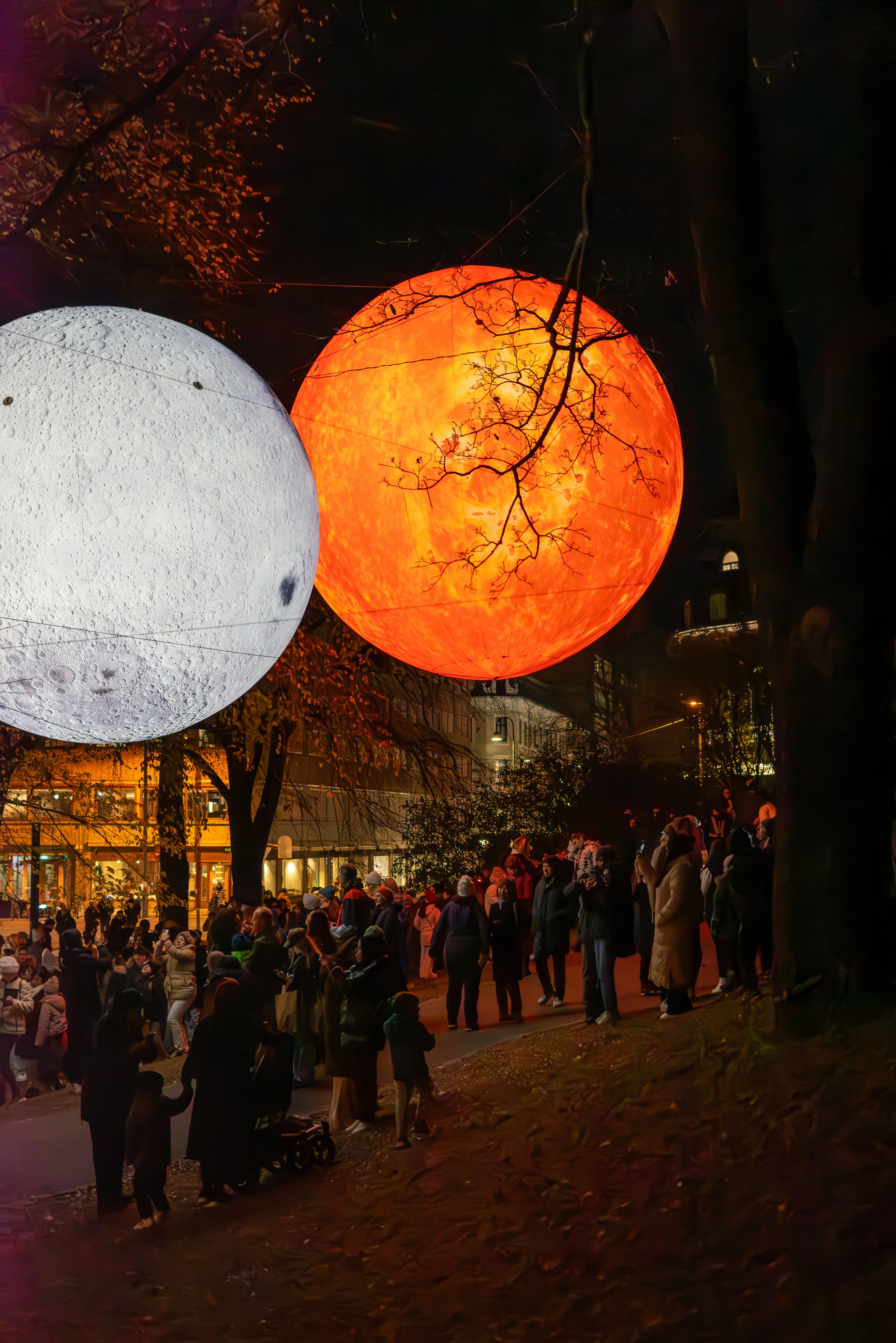 A large group of people standing around a park at night