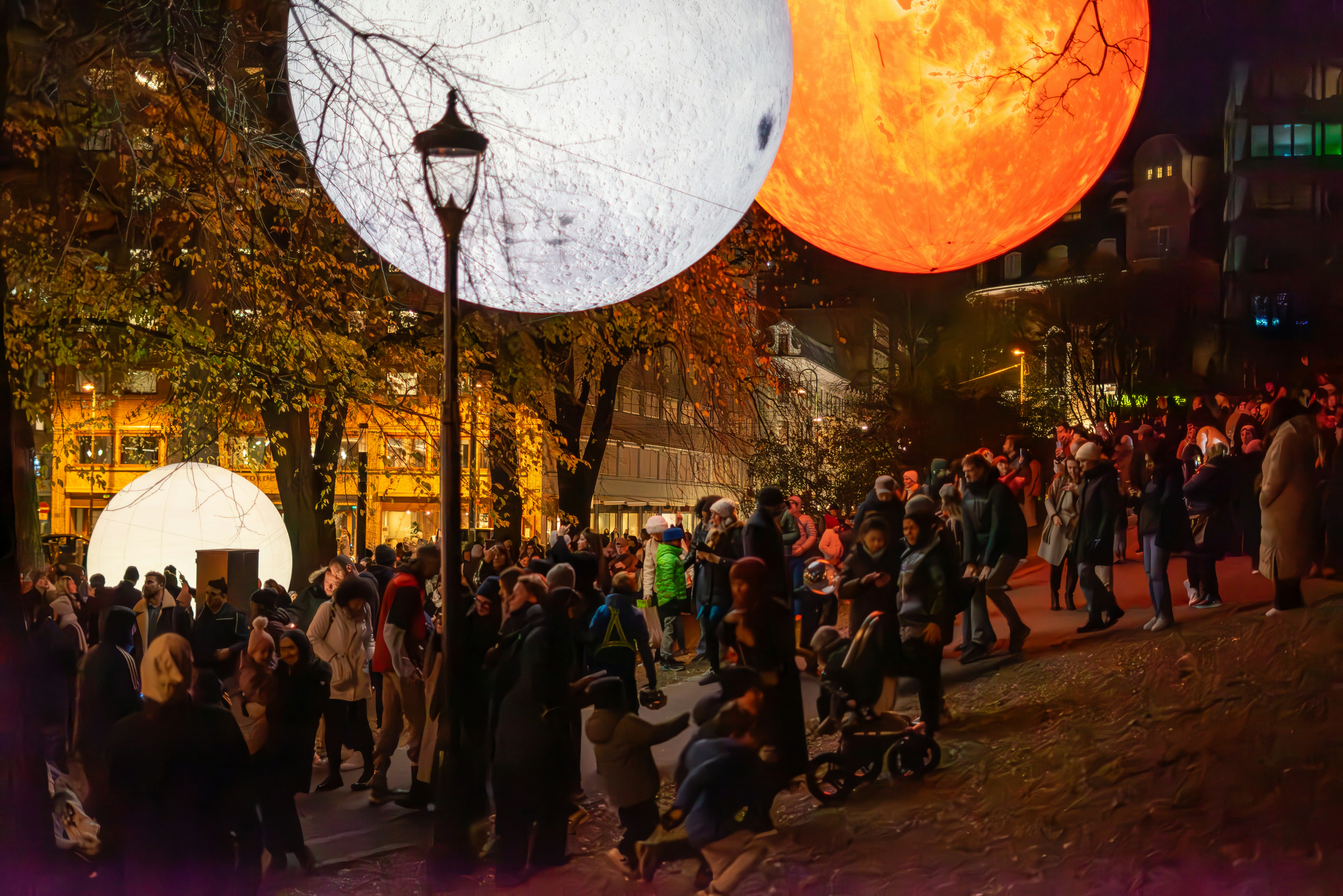 A group of people walking down a street at night