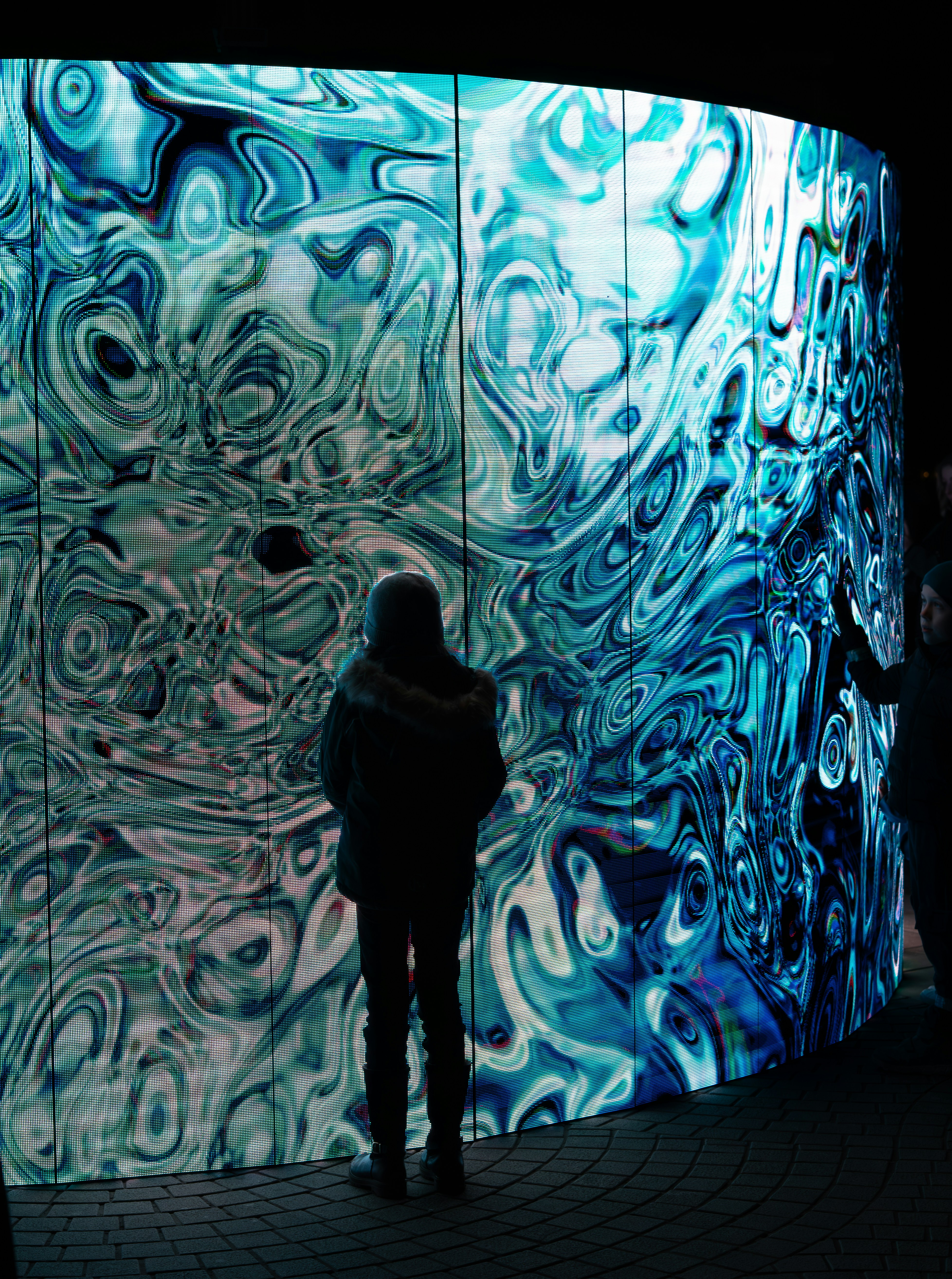 A person standing in front of a large wall