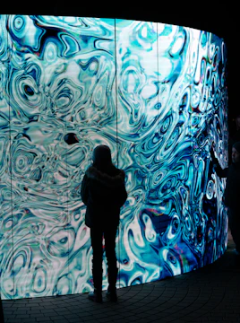 A person standing in front of a large wall