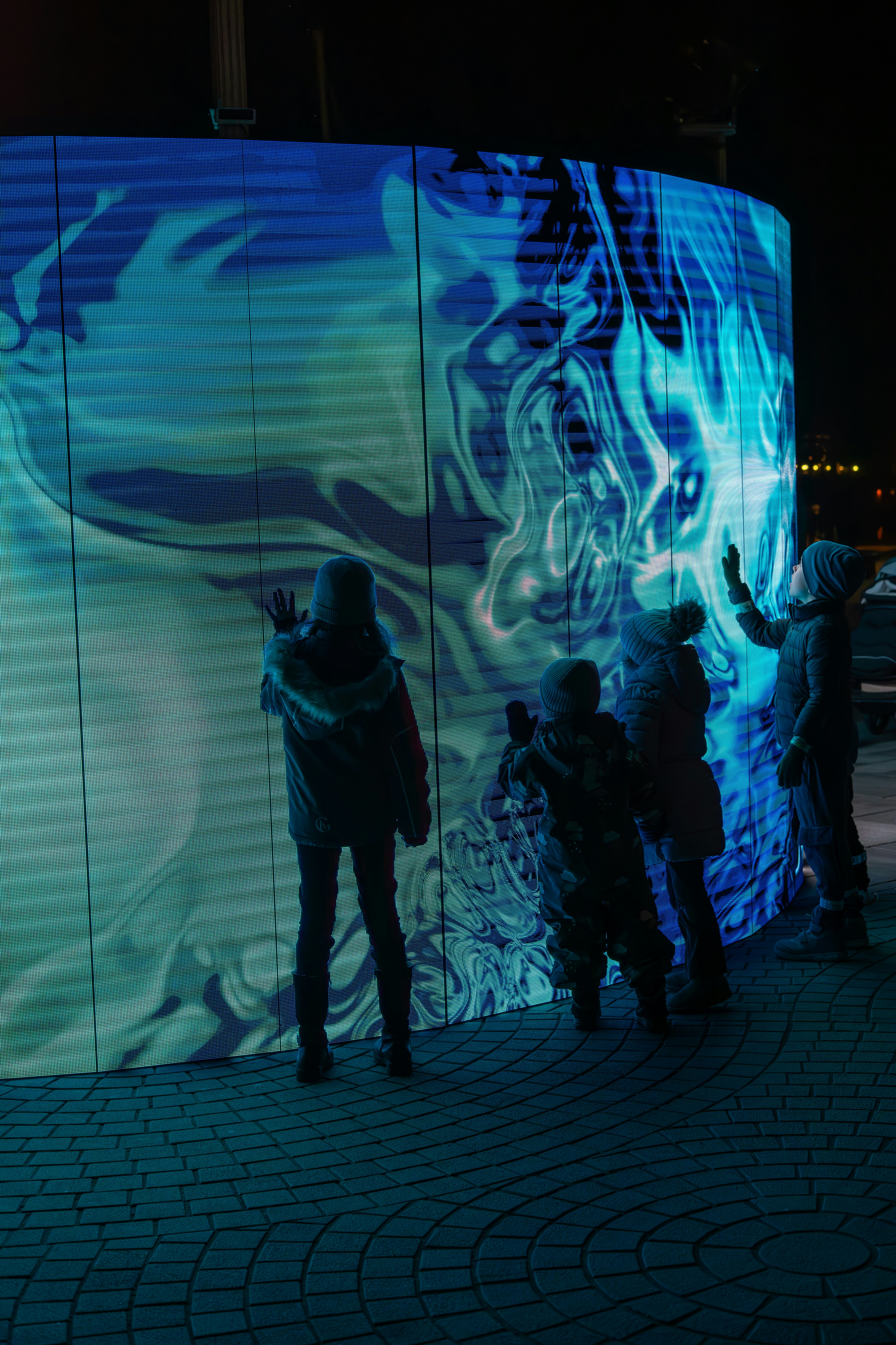 A group of people standing in front of a large screen