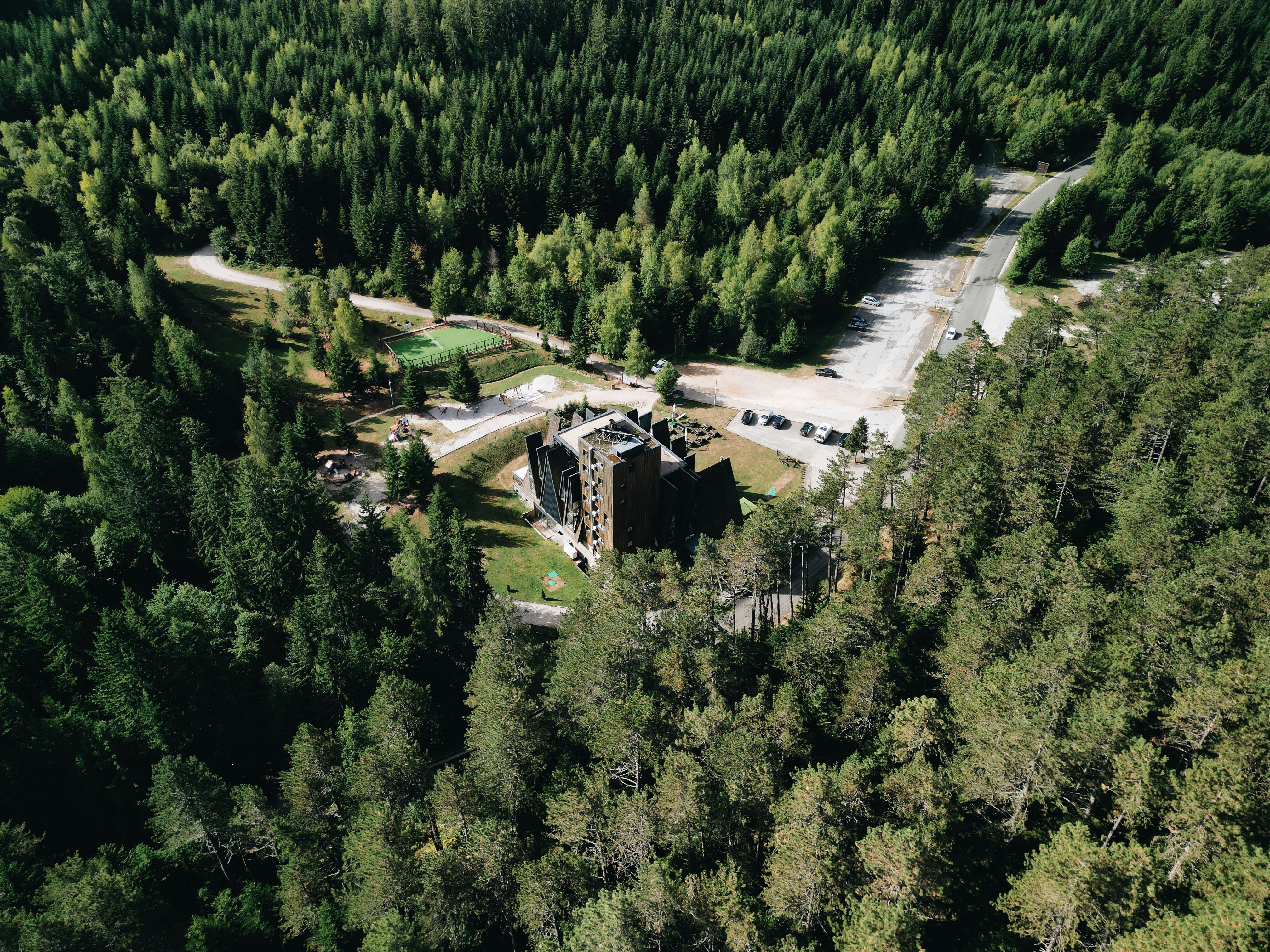 An aerial view of a building in the middle of a forest