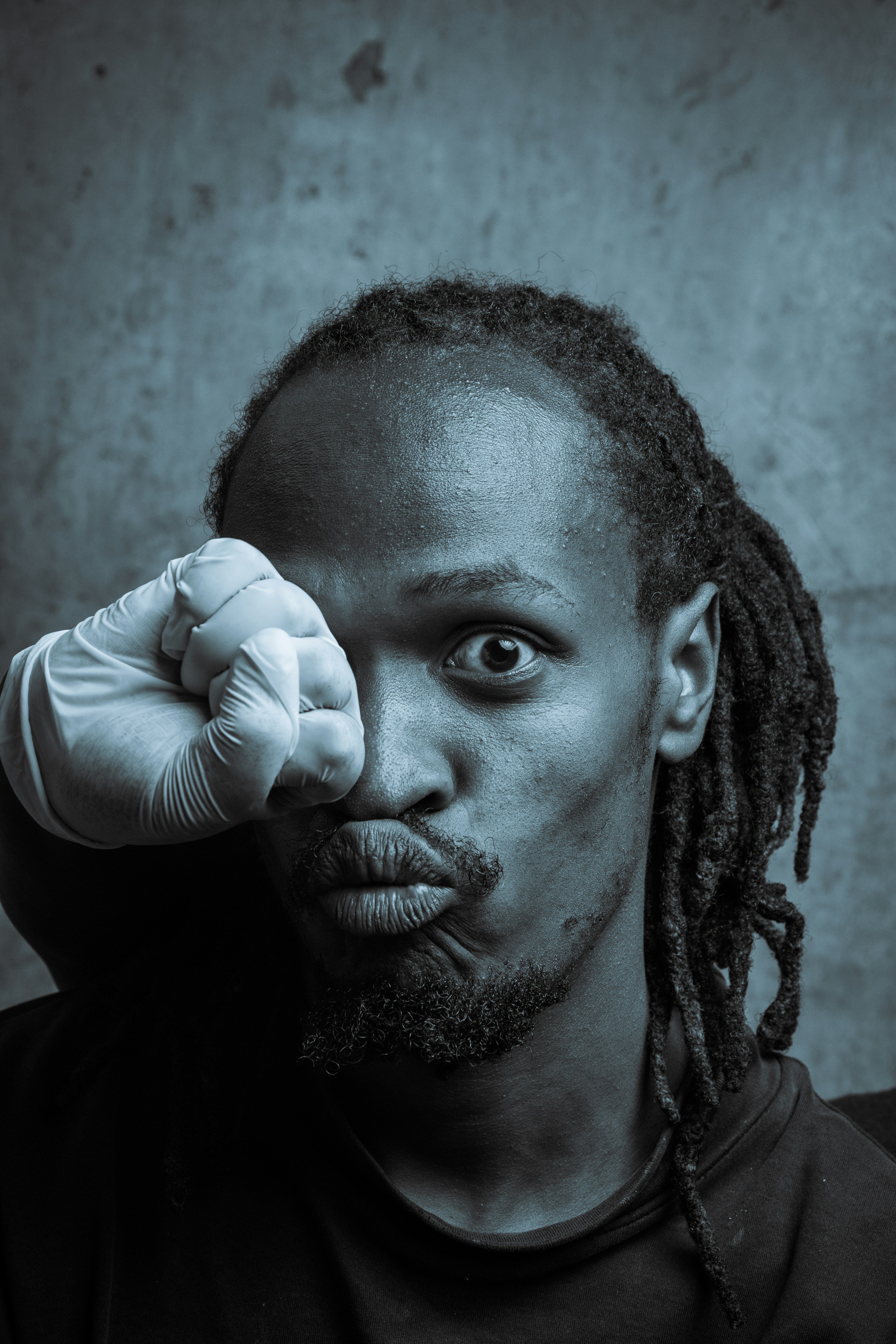 A man with dreadlocks is posing for a picture