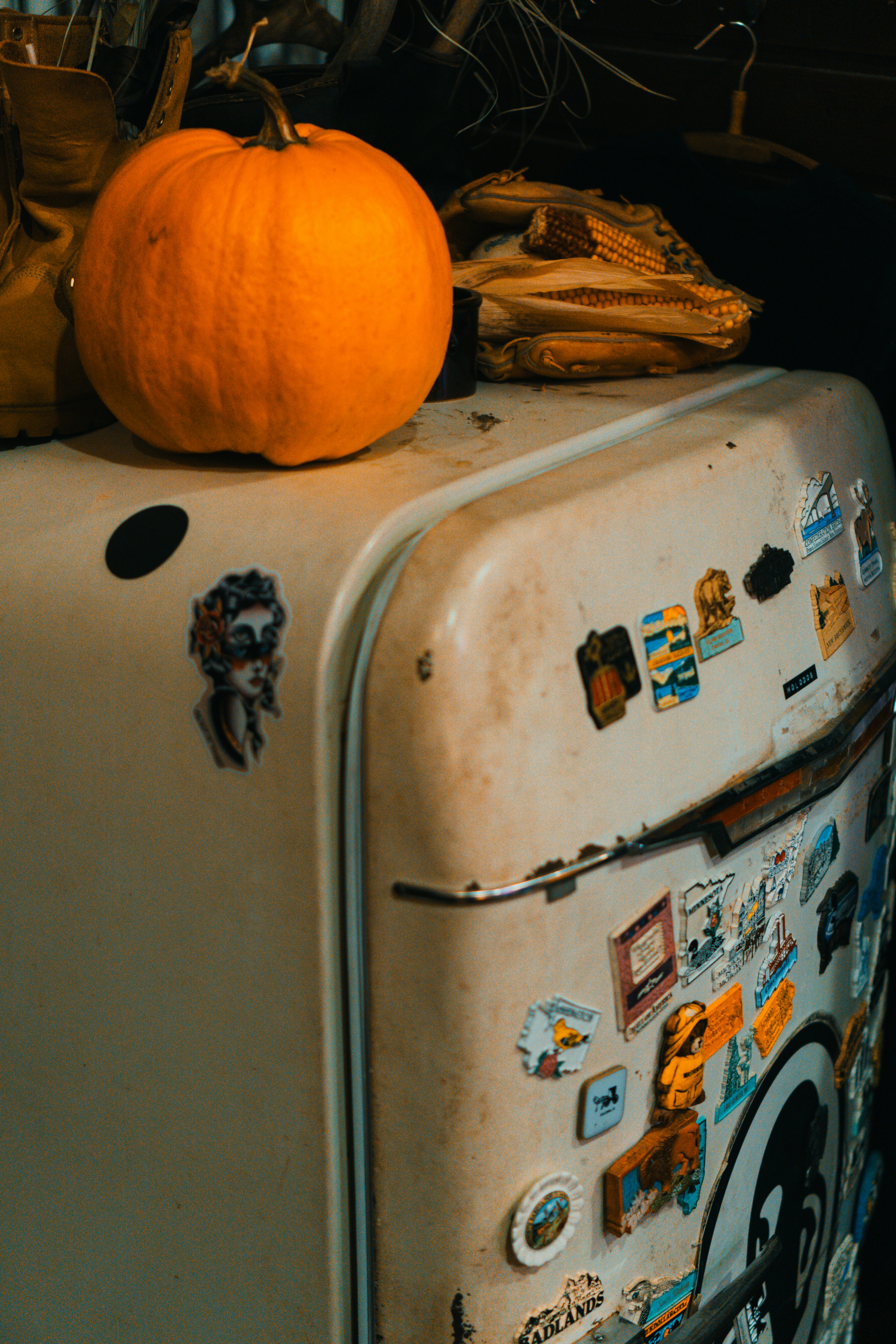 An old refrigerator with a pumpkin on top of it
