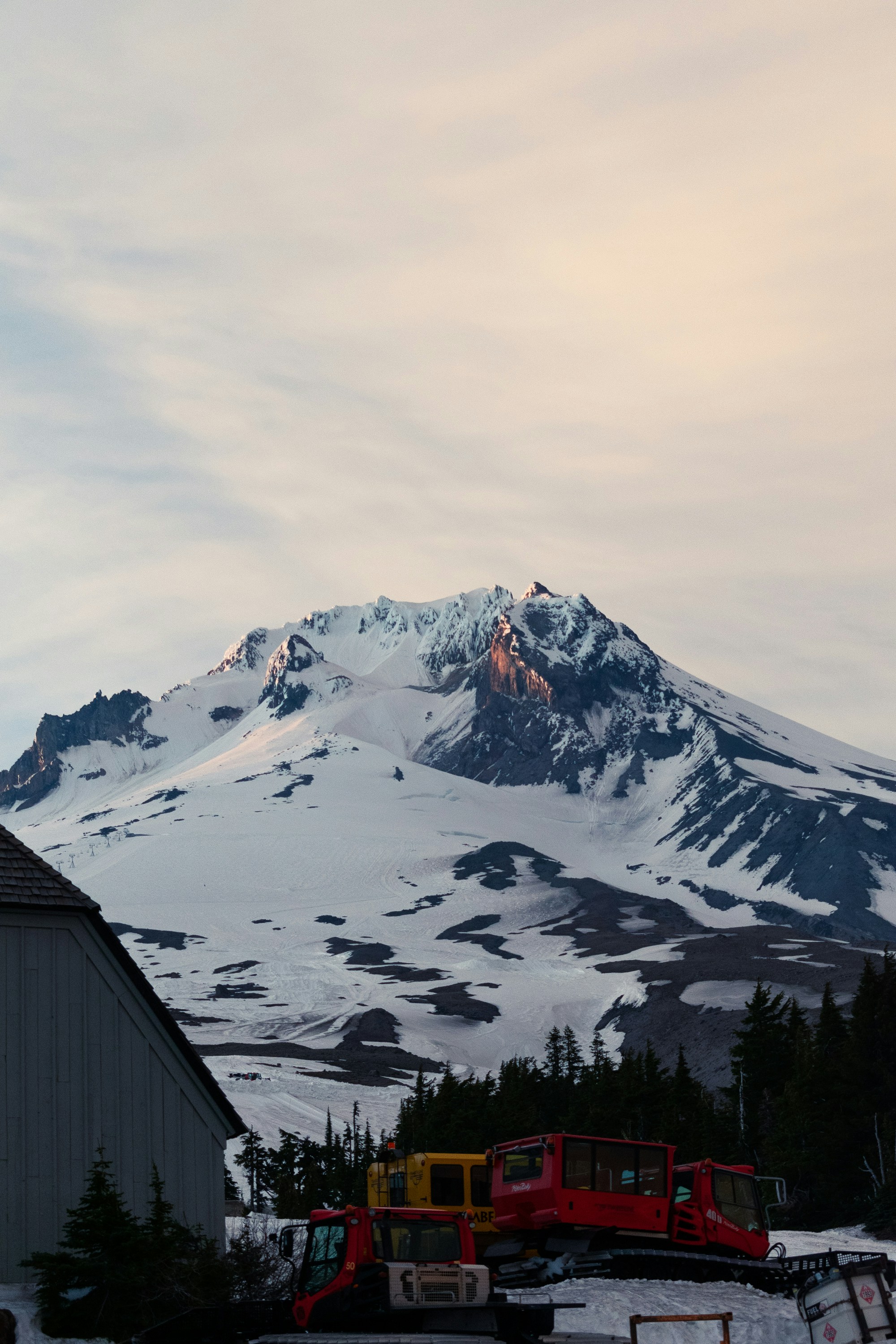 A mountain covered in snow next to a building