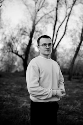 A black and white photo of a man wearing glasses