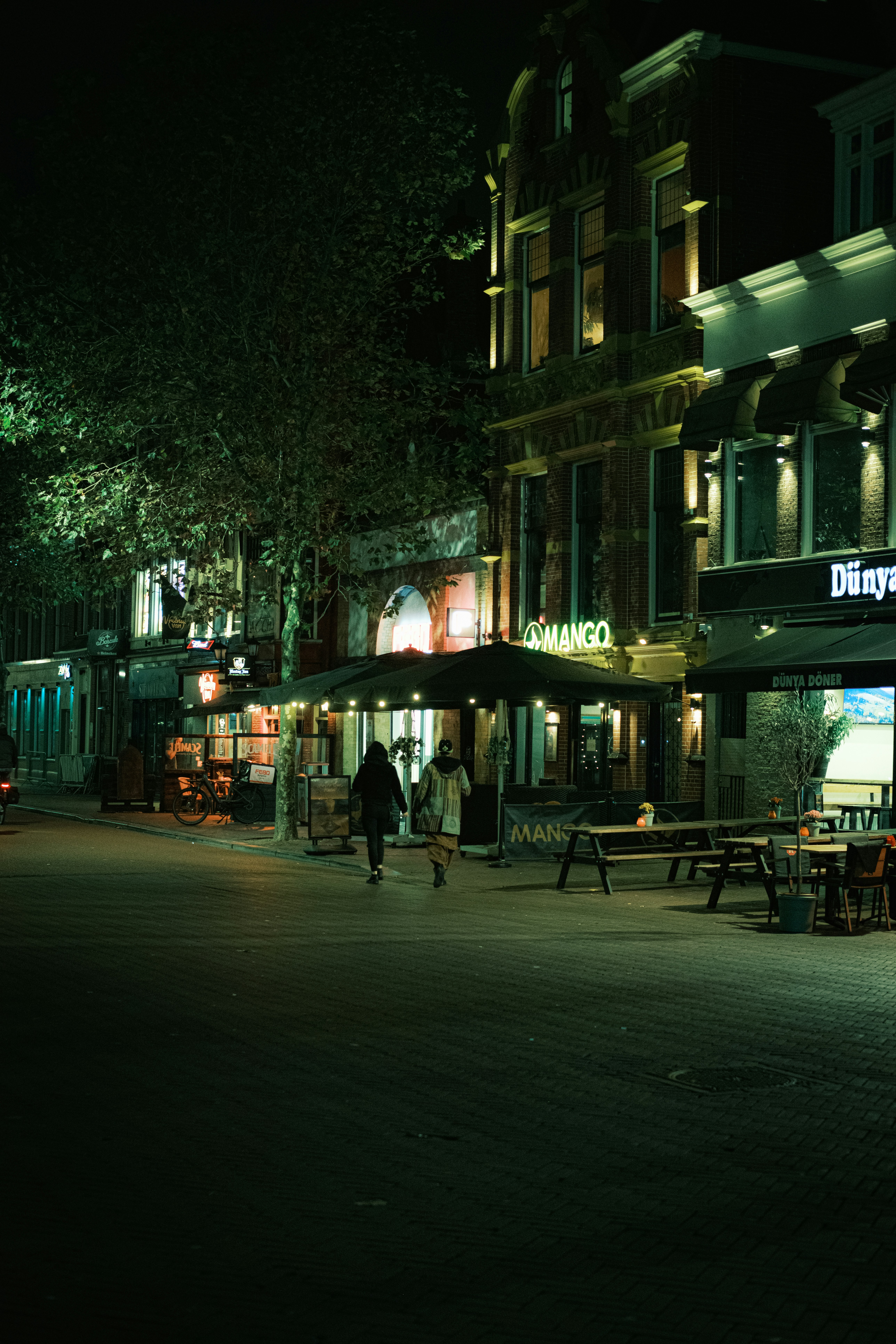 A person walking down a street at night