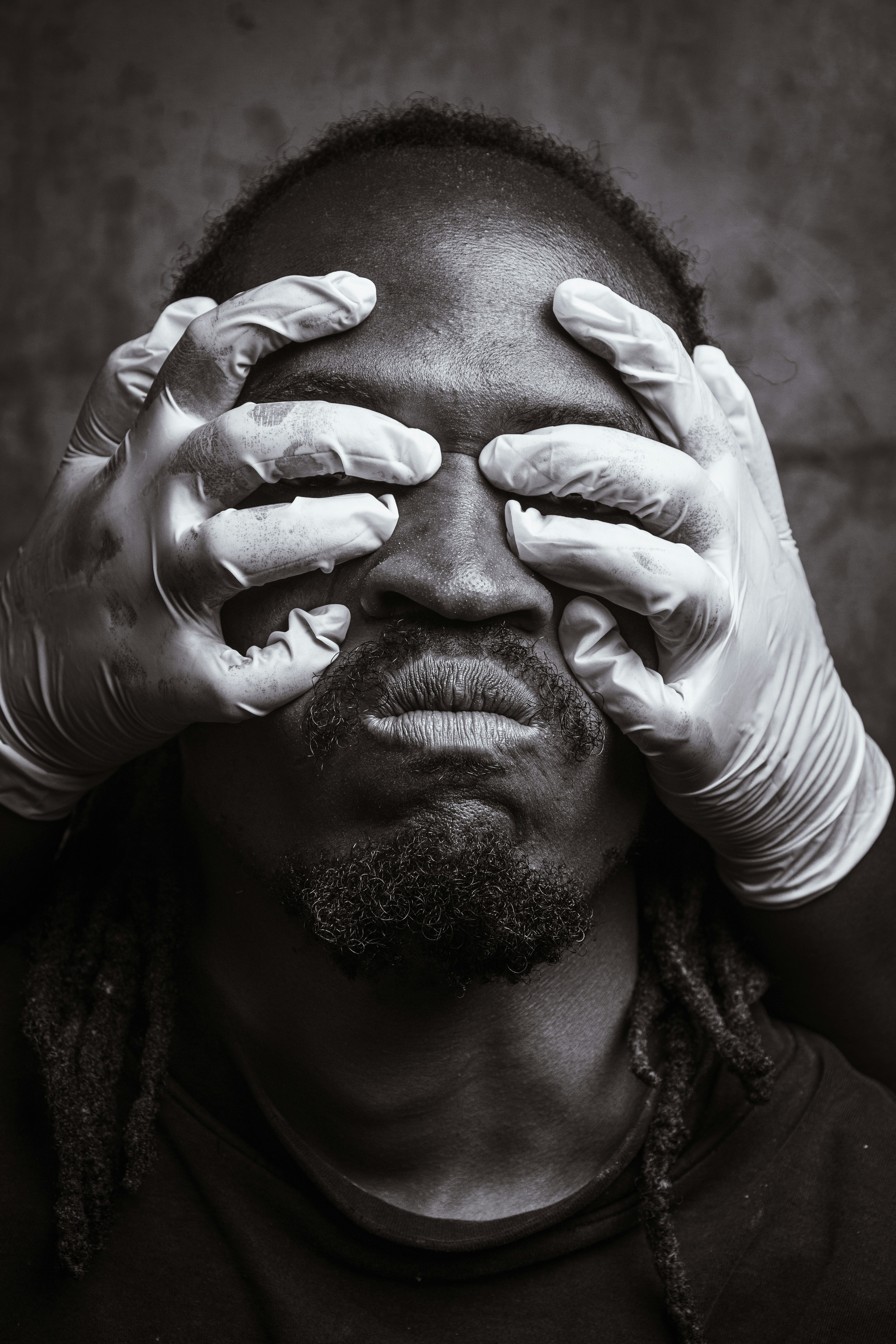 A man wearing gloves covering his eyes photo – Free Nairobi Image on ...