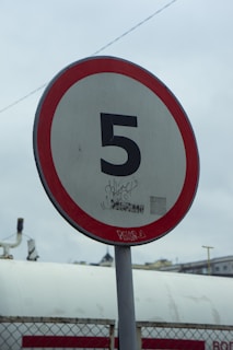 A red and white sign sitting on the side of a road