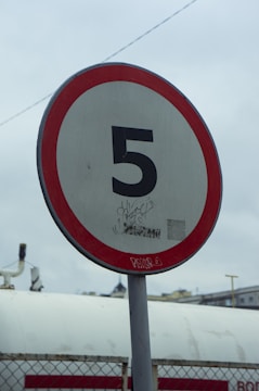A red and white sign sitting on the side of a road