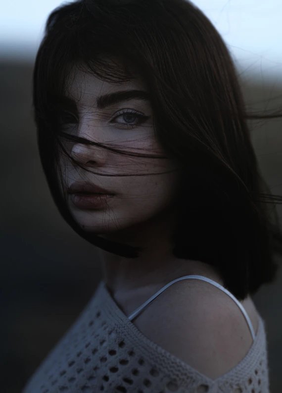 A woman with long hair and a white top
