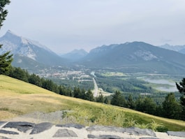 A view of a valley and mountains from the top of a hill