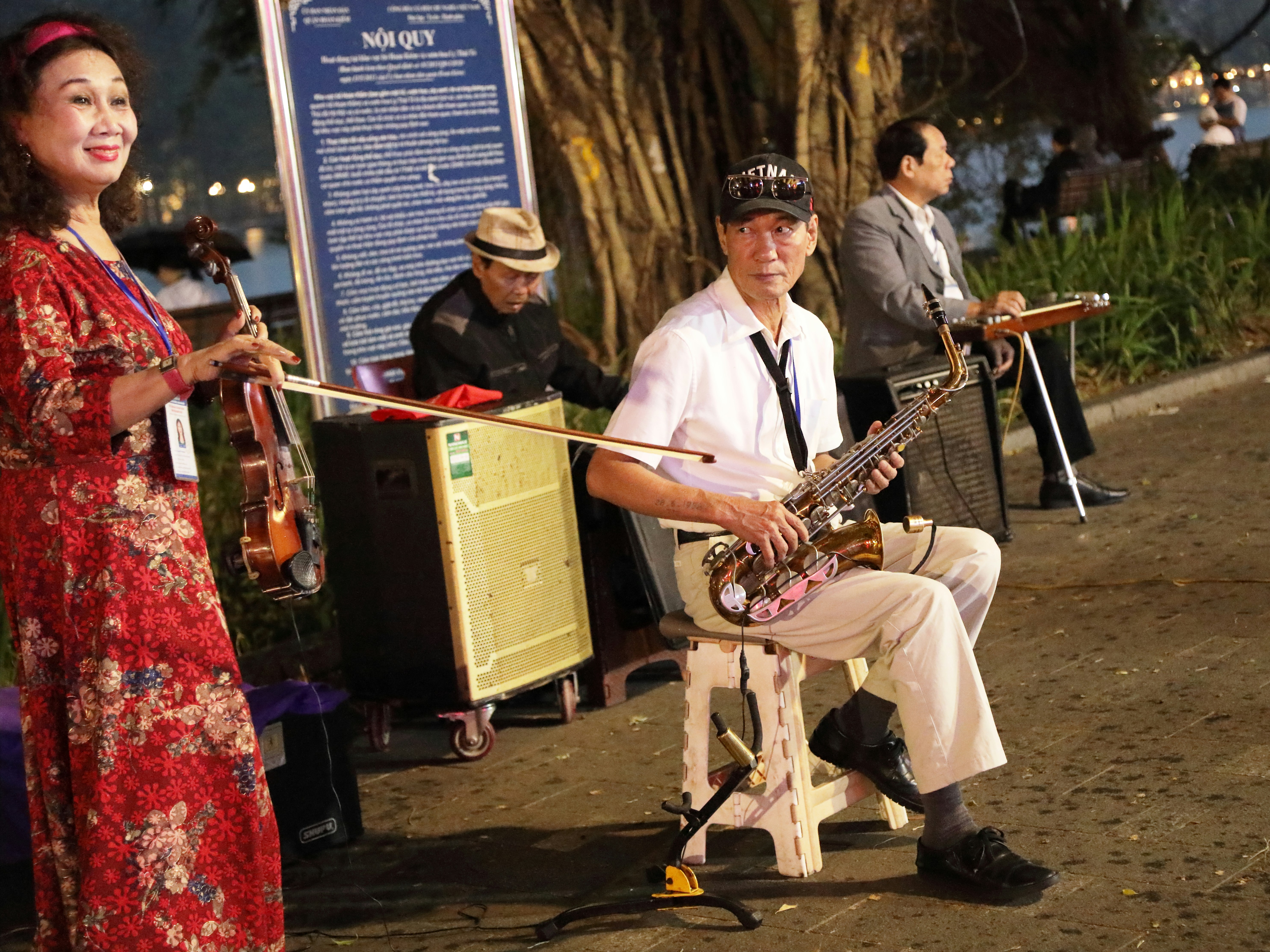 A woman in a red dress playing a guitar