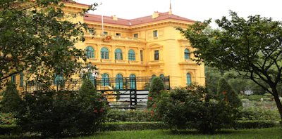 A large yellow building with trees in front of it