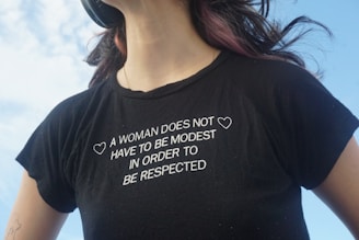 A woman wearing a t - shirt that says a woman does not have to be