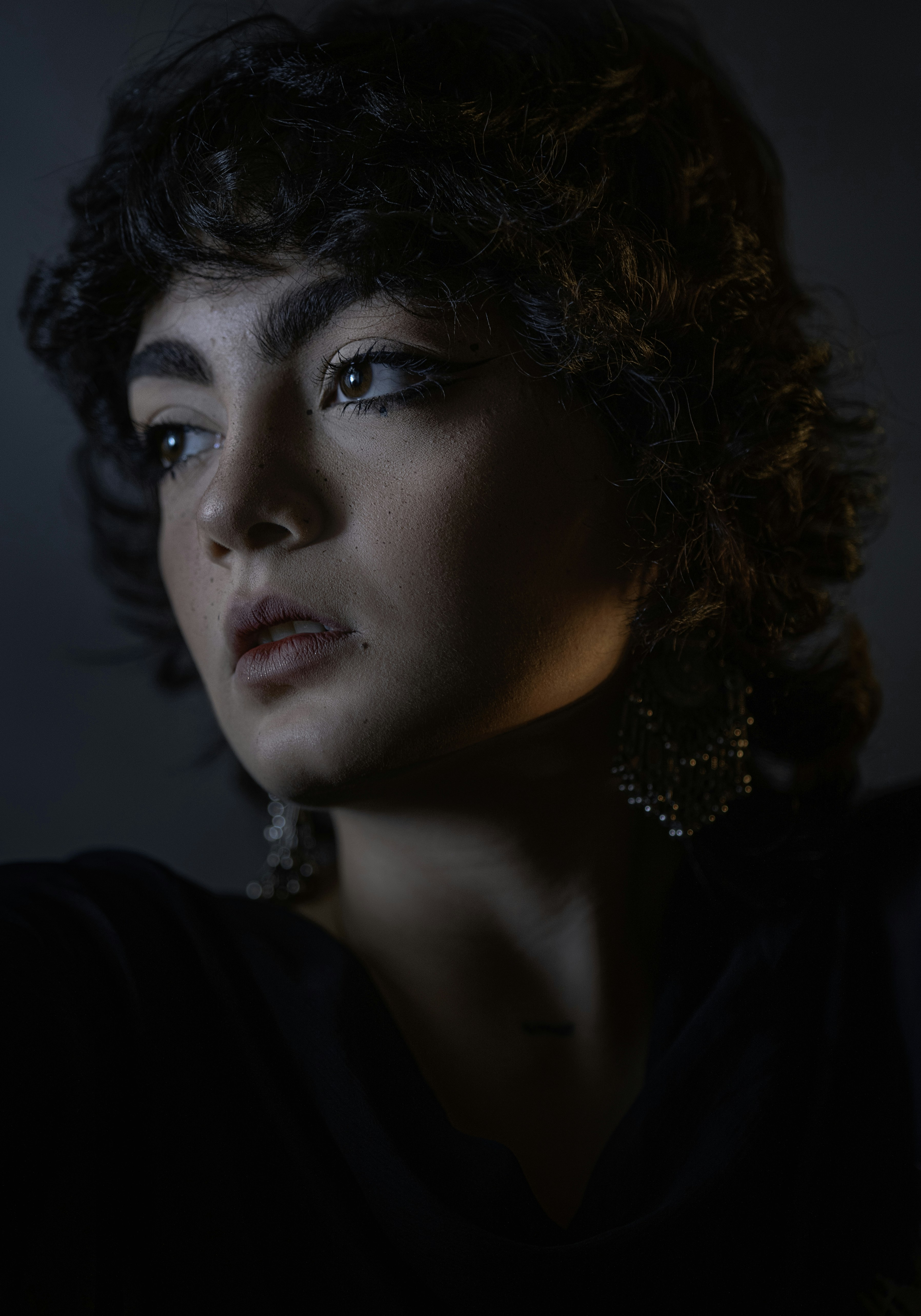 A woman in a dark room with a candle in her hand