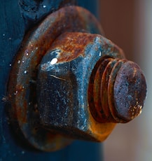A rusted fire hydrant with a blue door in the background