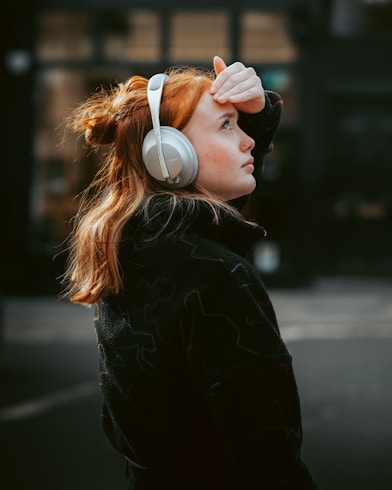 A woman wearing headphones standing on the street