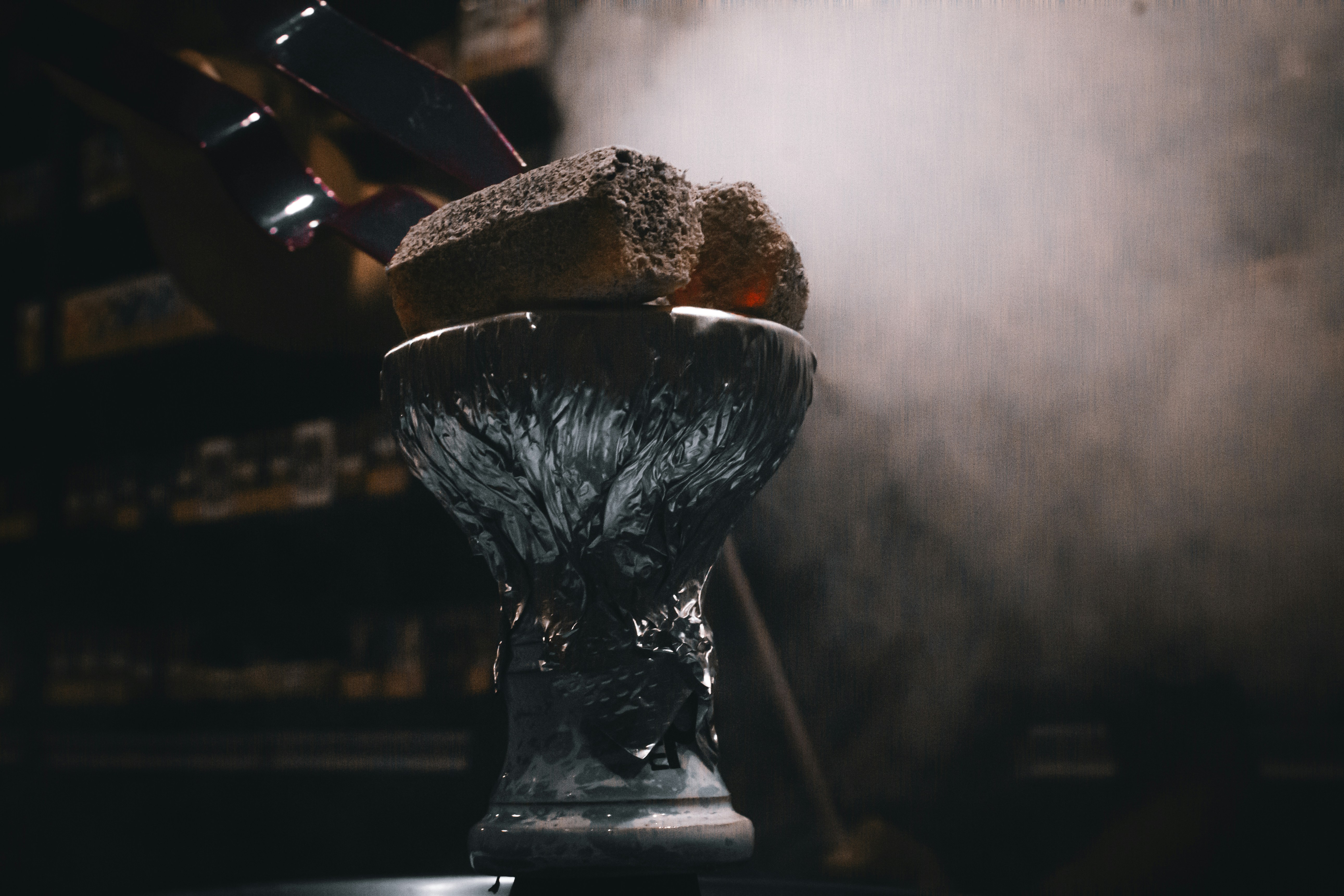 A dark room with smoke coming out of a vase