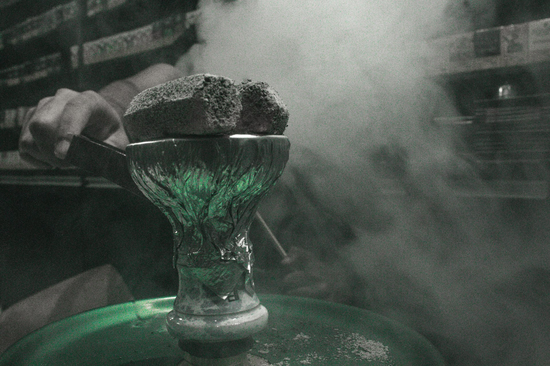A person is smoking a cigarette on a green tray