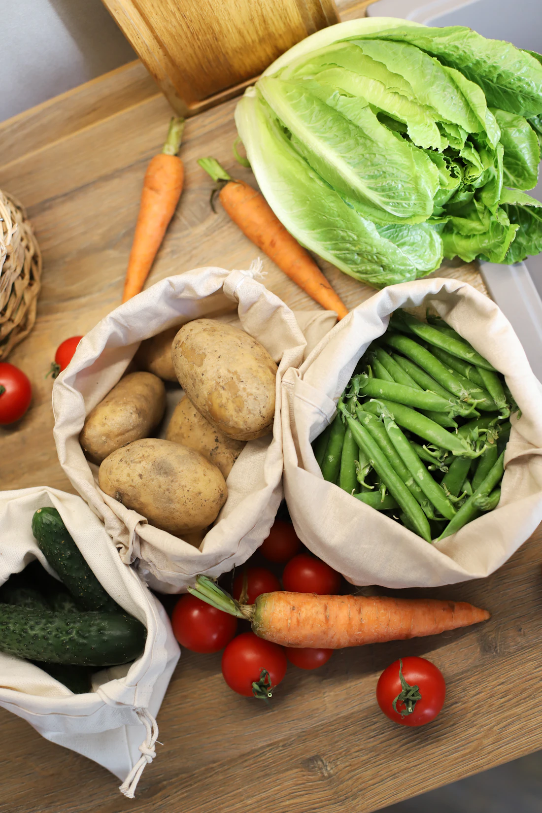 Fresh produce in cloth bags on a kitchen table