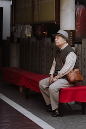 A man sitting on a bench in front of a building