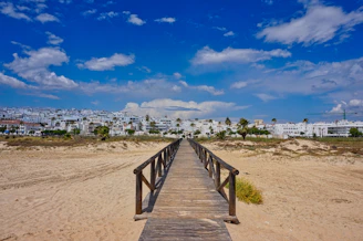A wooden walkway going across a sandy beach