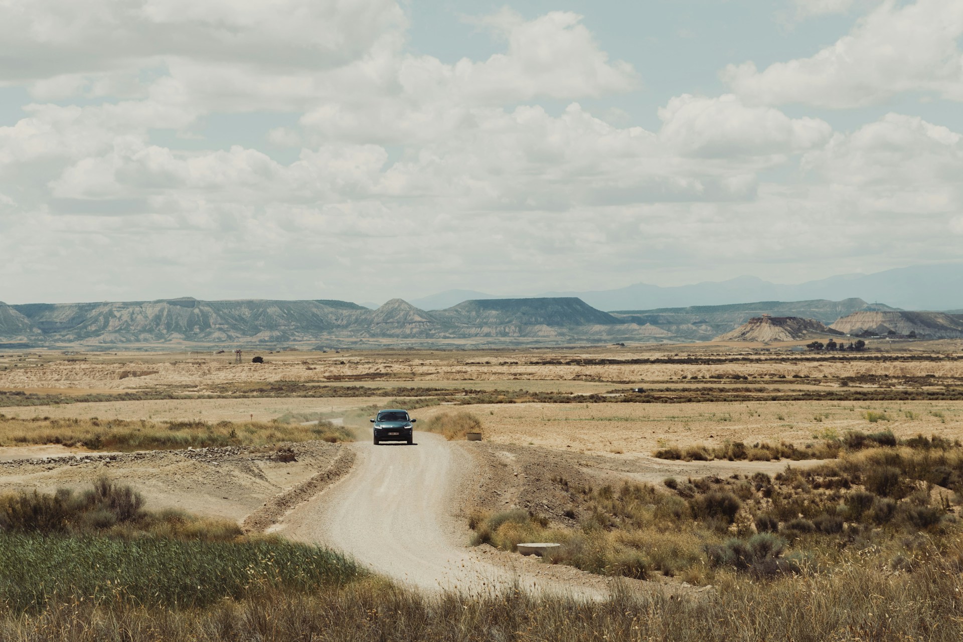 A truck is driving down a dirt road