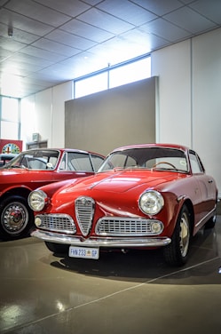 A couple of red cars parked next to each other