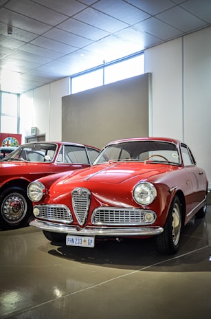 A couple of red cars parked next to each other