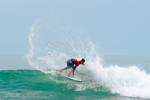 A man riding a wave on top of a surfboard