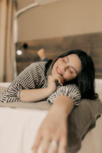 A woman laying on a bed with her eyes closed