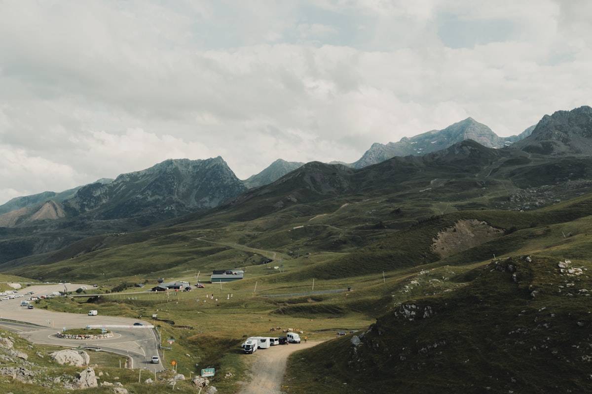 A car driving down a dirt road in the mountains