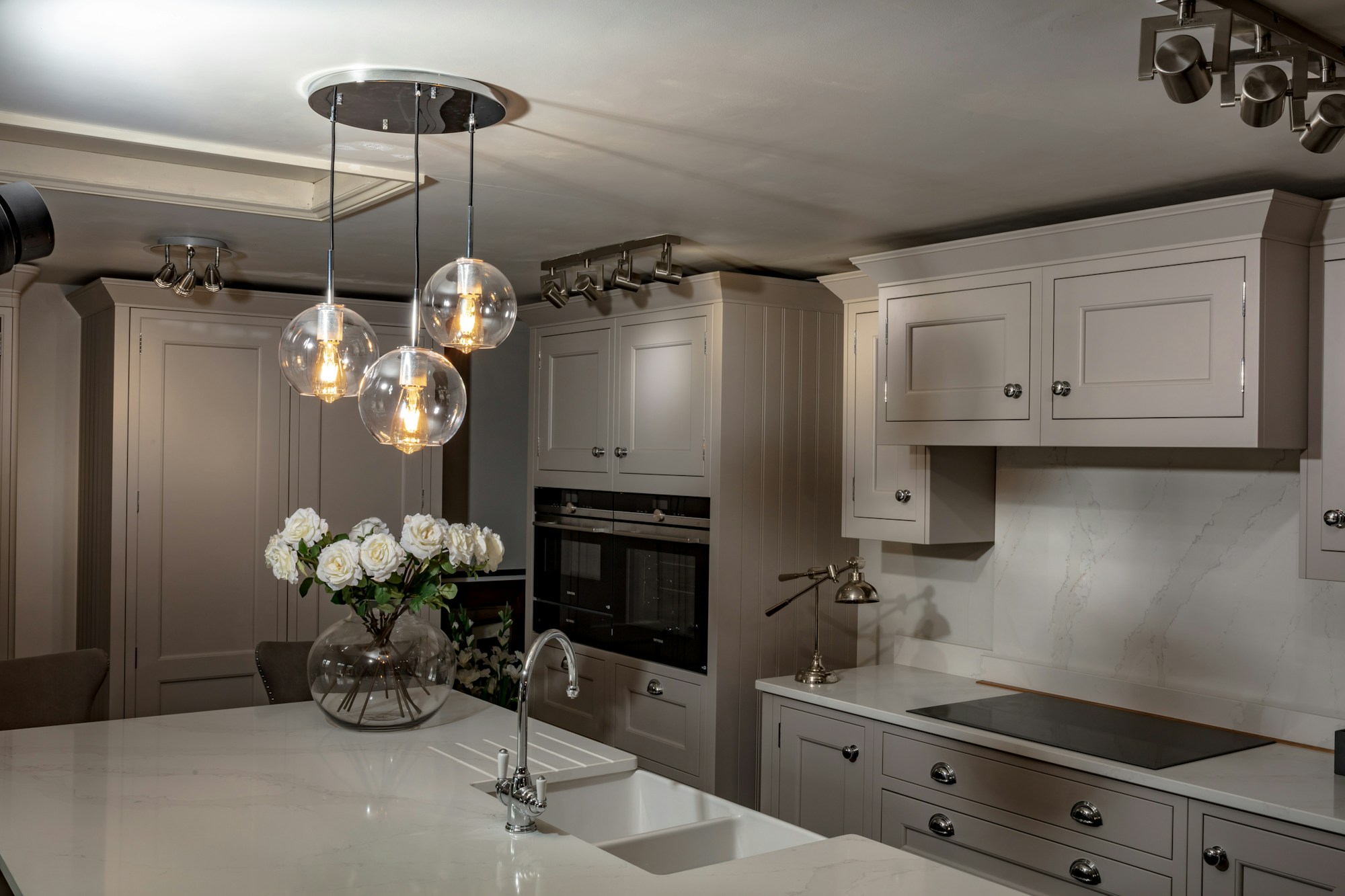 Large kitchen with a center island lit by a statement light fixture