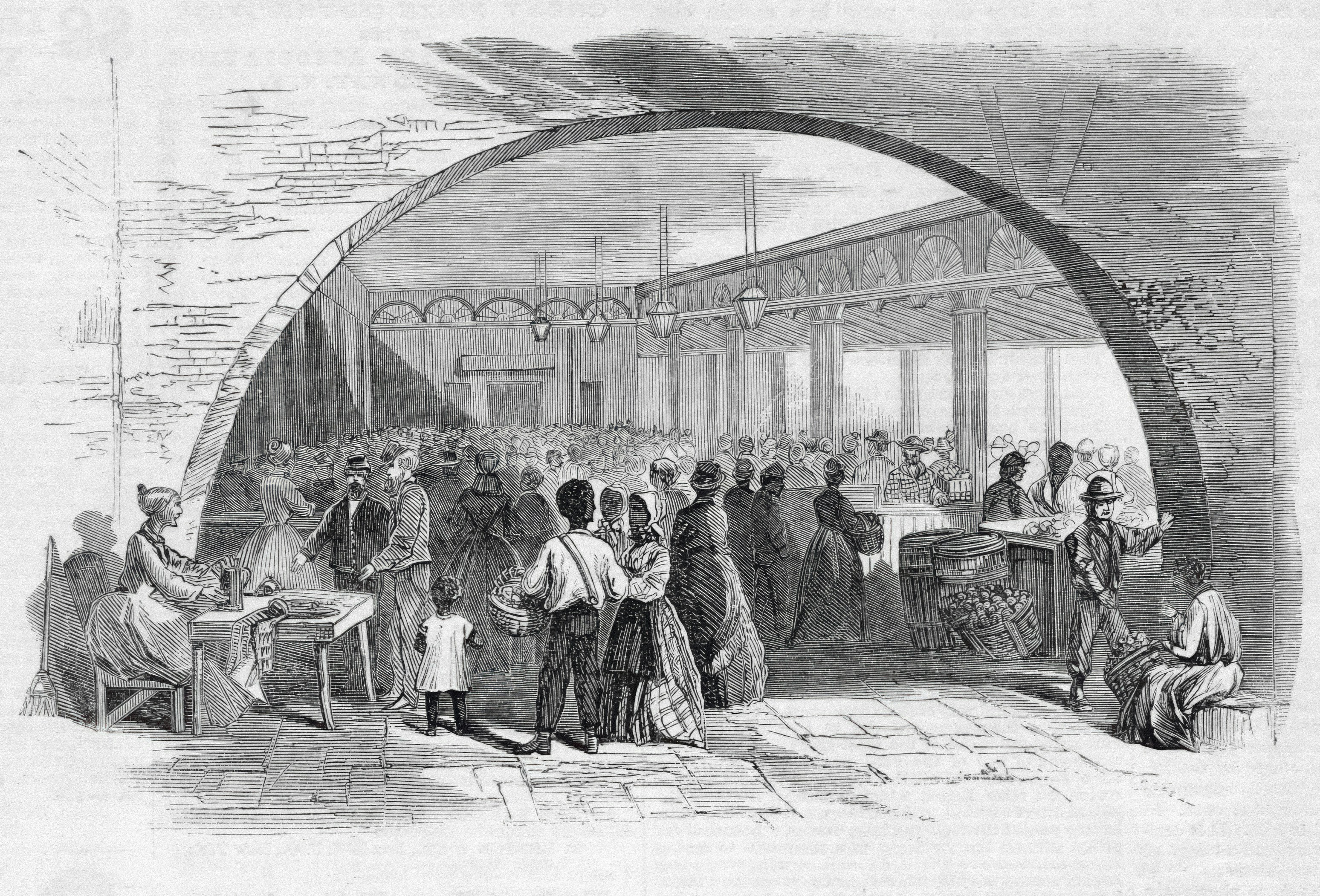 People gathered in a large hall with arched windows.