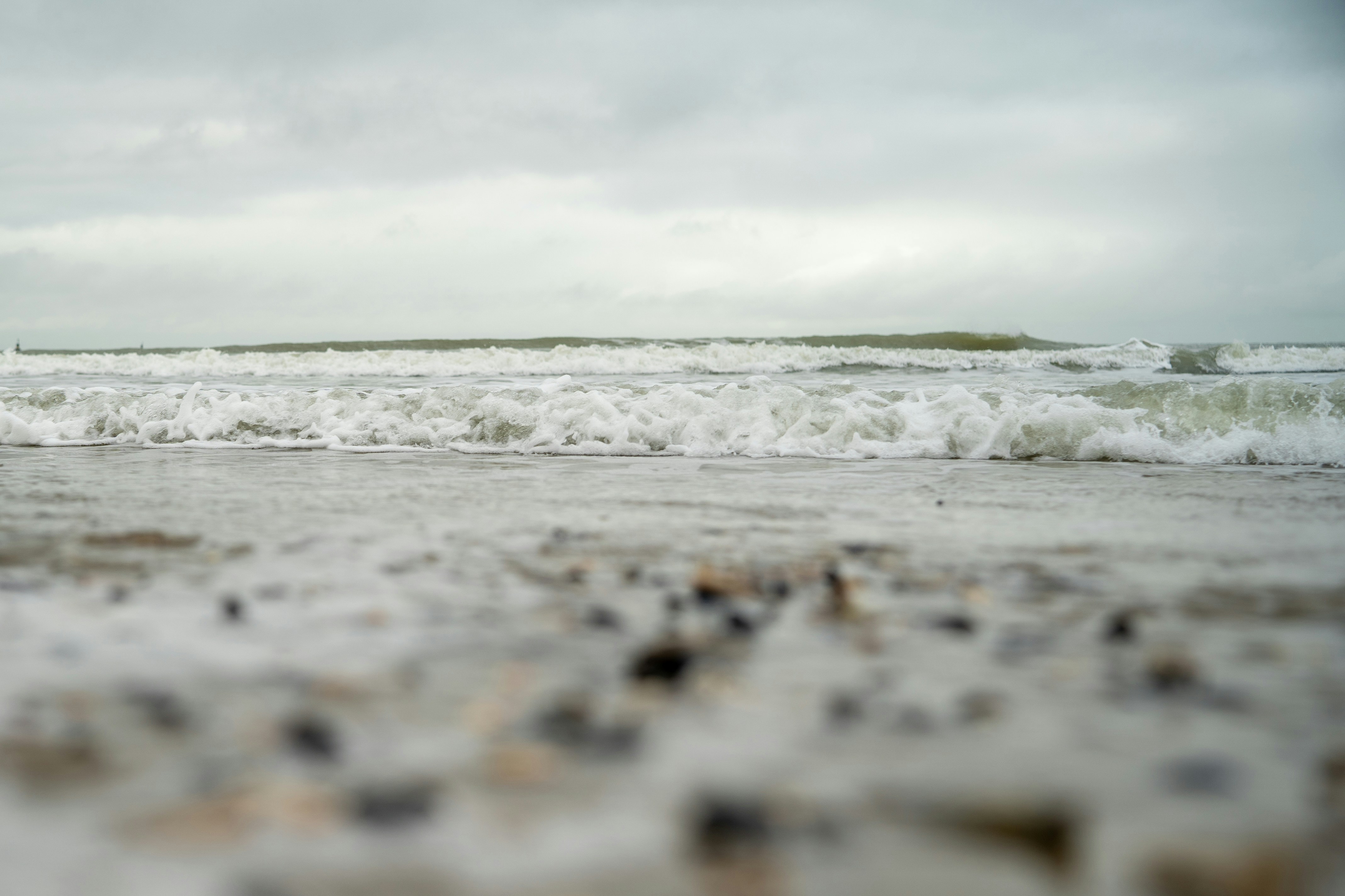 A blurry photo of a beach with waves coming in, 