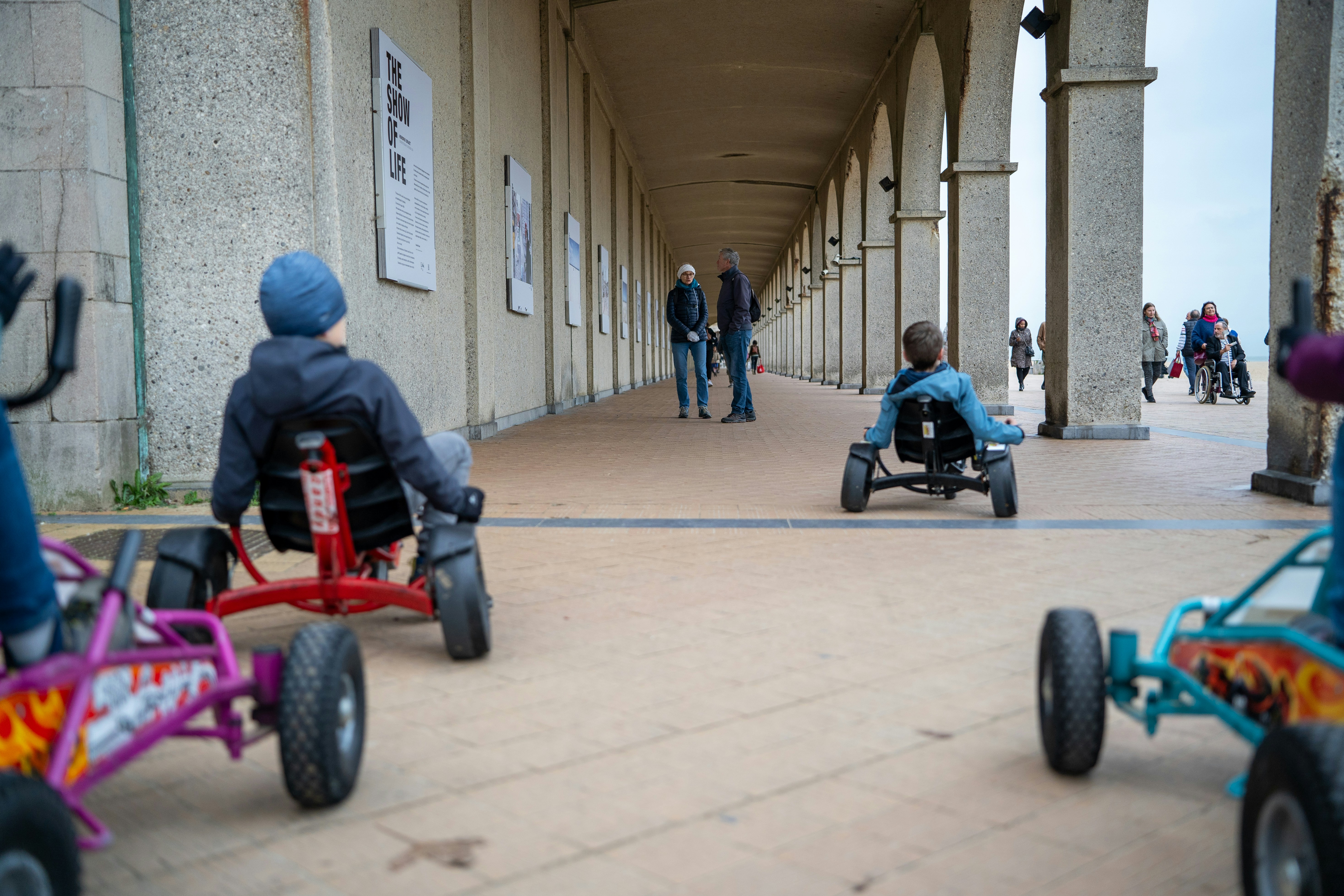 A group of people riding on top of four wheeled vehicles
