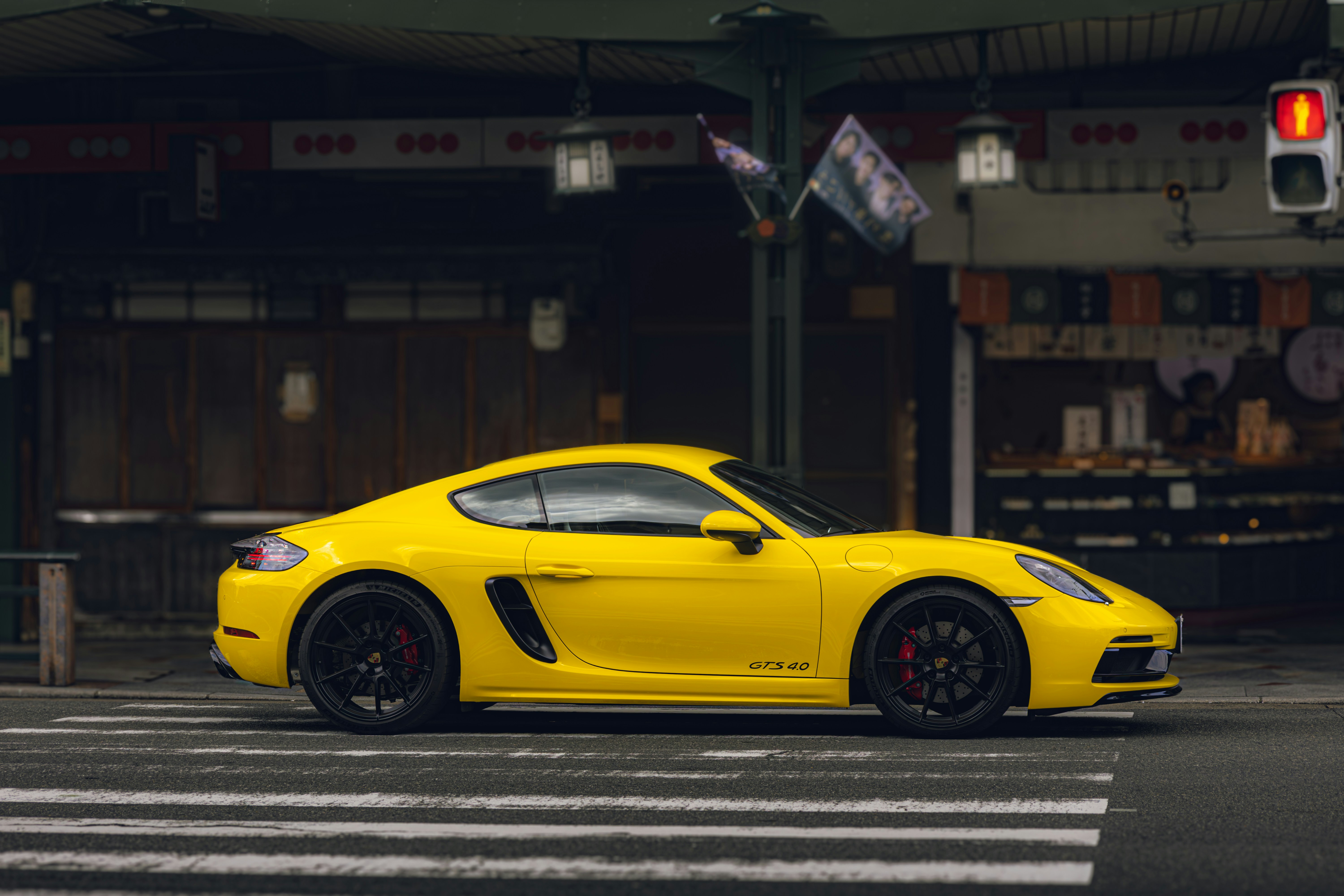 A yellow sports car driving down a street