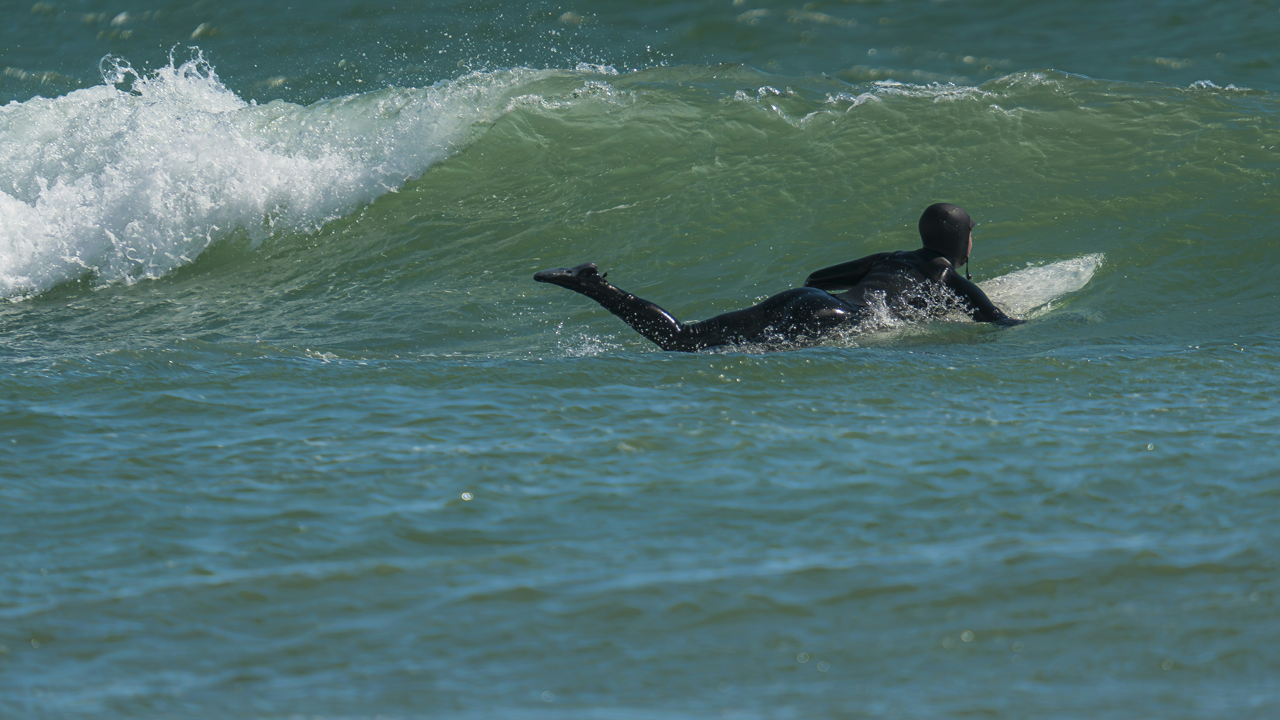 A person riding a surfboard on a wave in the ocean