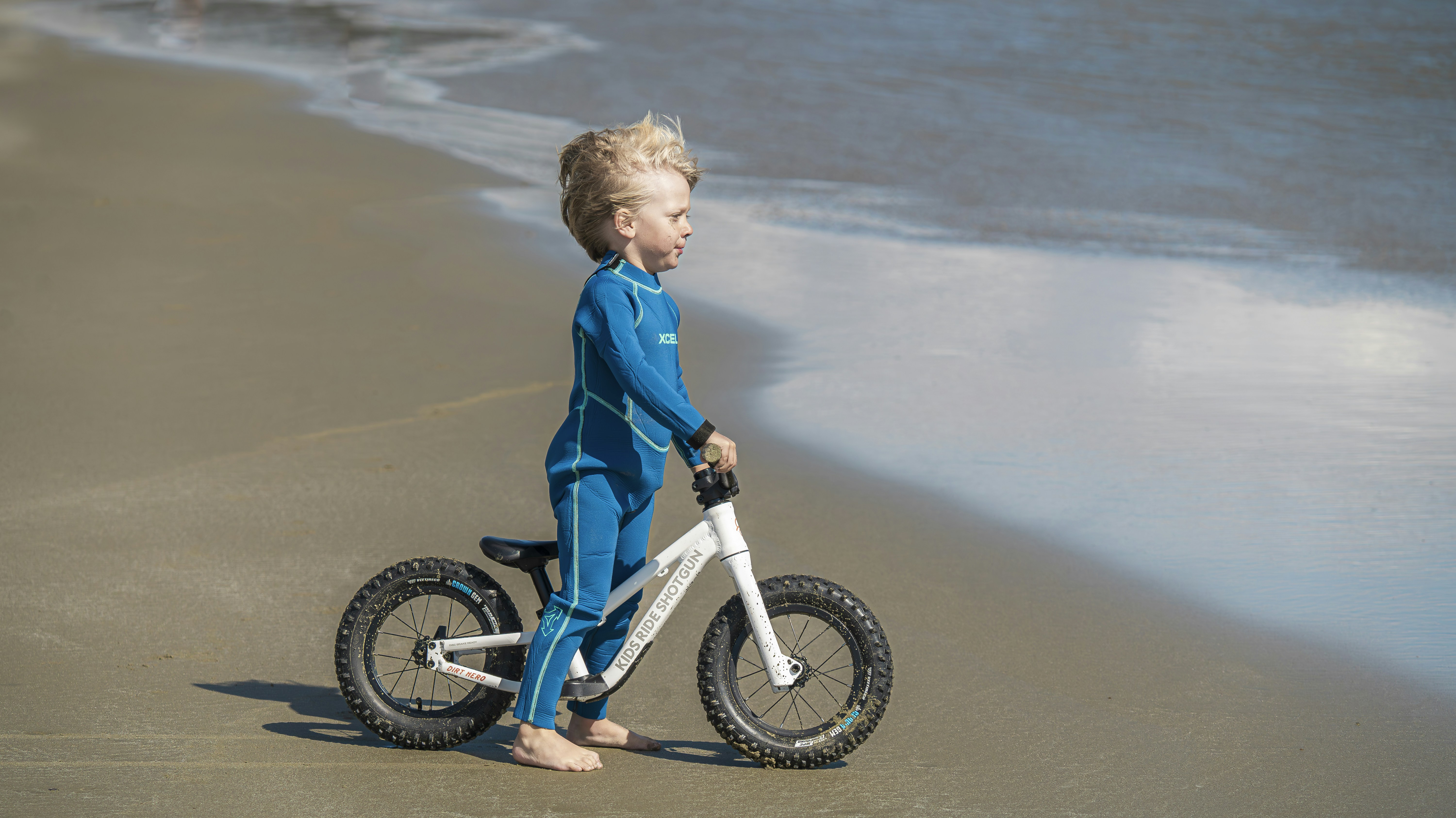 A young boy riding a bike on the beach